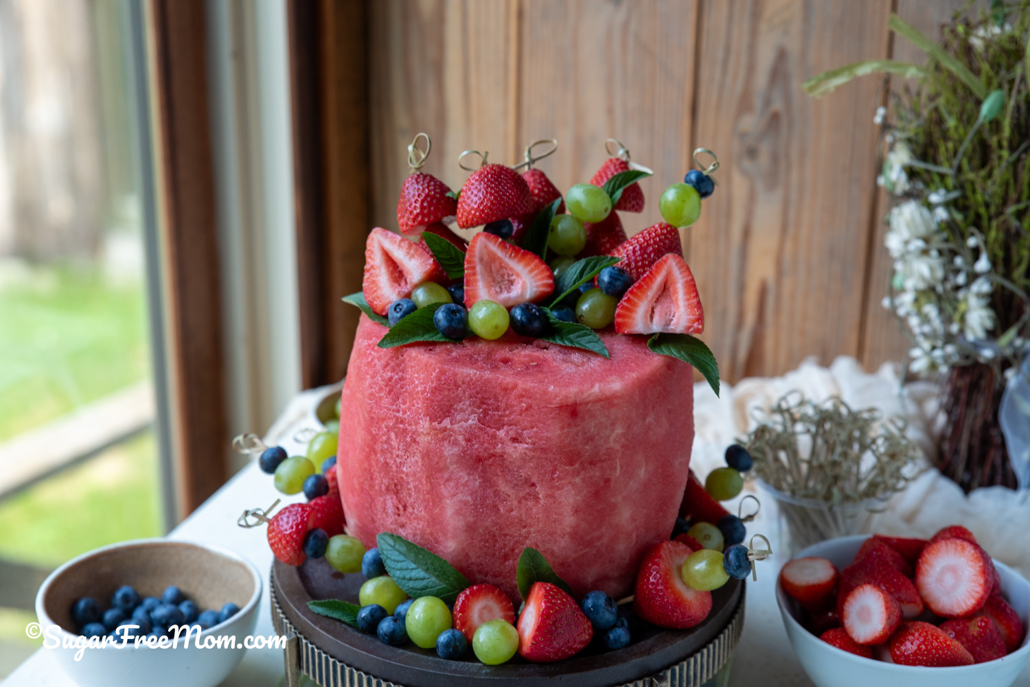 Looking for a beautiful birthday cake made with fresh fruit instead of flour, frosting, and sugar? This Easy Flourless Fresh Fruit Watermelon Cake Recipe is the perfect centerpiece for summer birthdays, baby showers, graduation parties, cookouts, and special occasions.