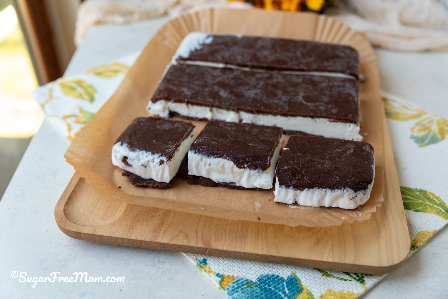 horizontal image of 3 sliced keto ice cream sandwiches on cutting board