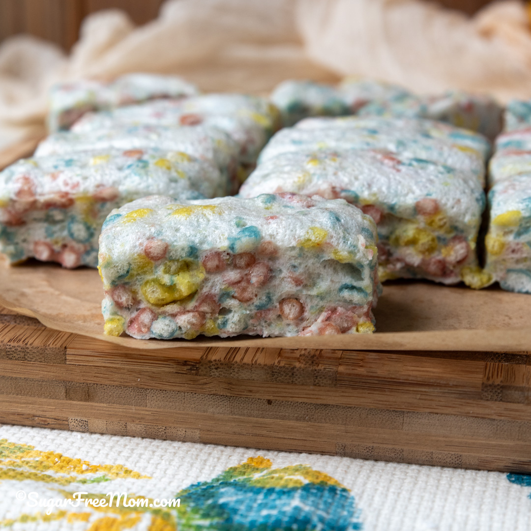 square image of close up of keto marshmallow rice krispie treat on cutting board