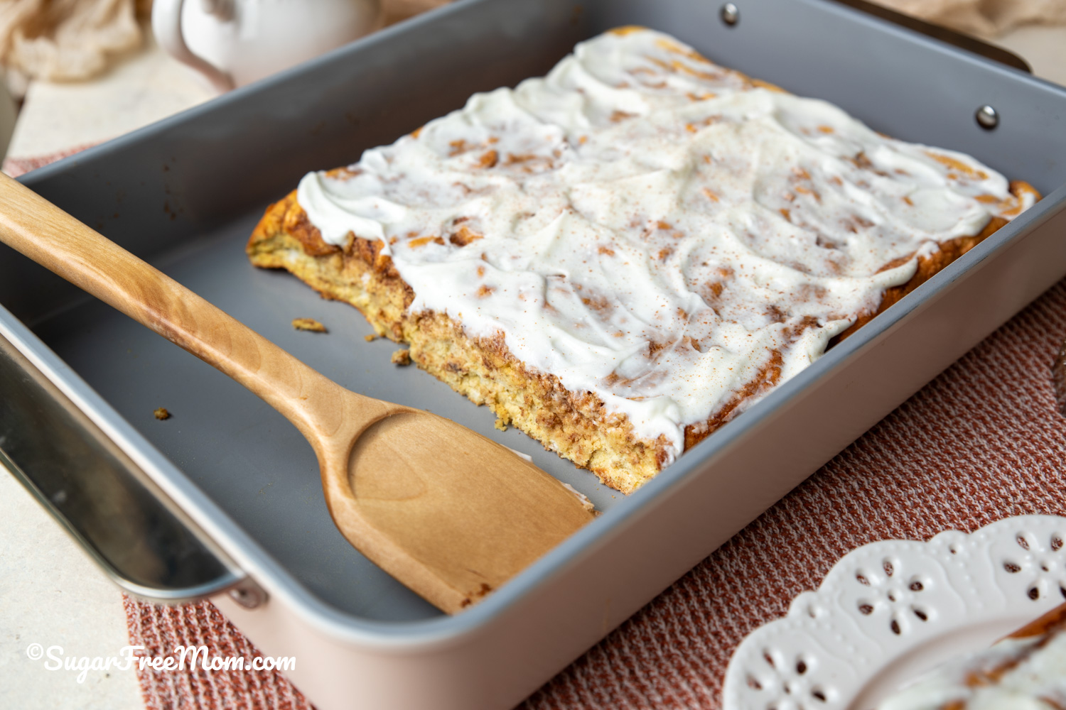 9 by 13 baking dish with wooden spatula and keto cinnamon roll sheet pan pancakes