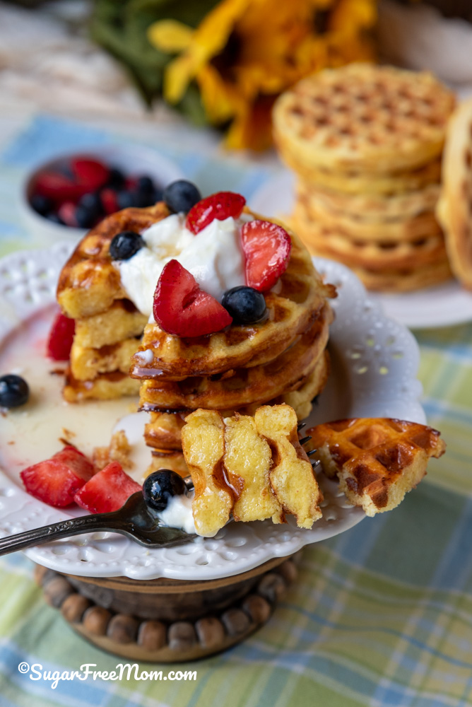 keto coconut flour waffles on a white plate with a fork of 3 pieces