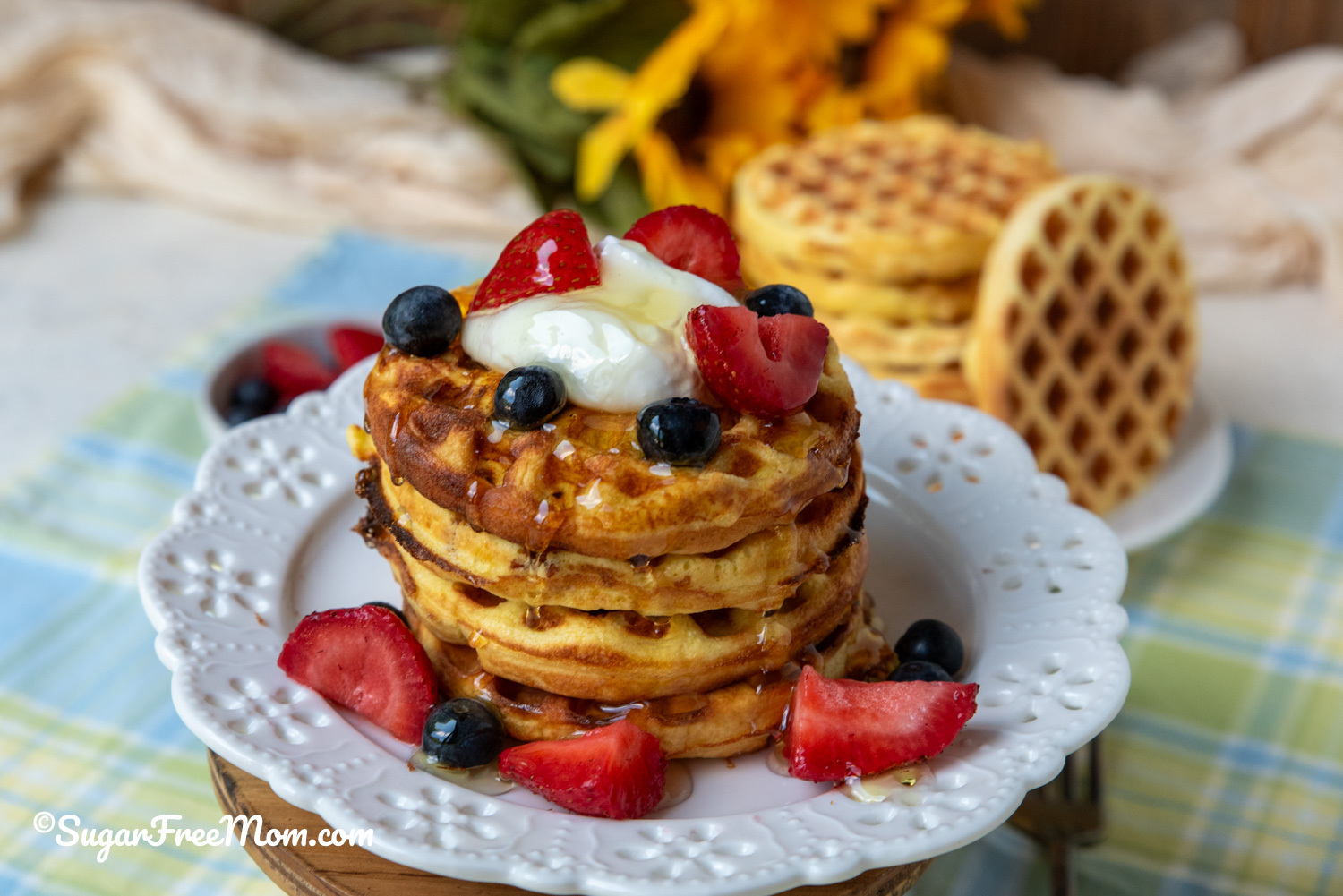 horizontal image of coconut flour protein waffles with berries, yogurt and syrup