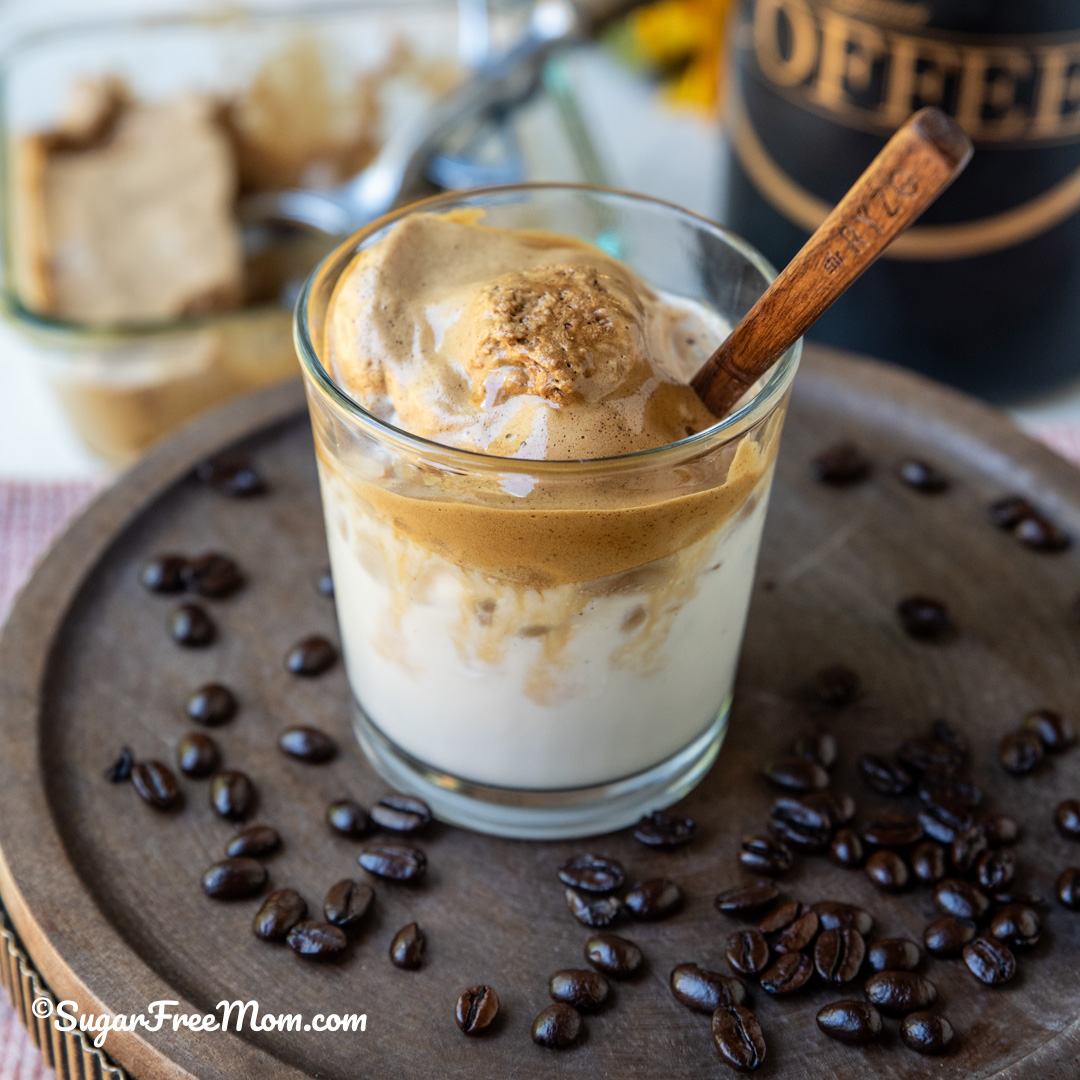 close up of melted keto frozen whipped Dalgona coffee in a glass with a wooden spoon