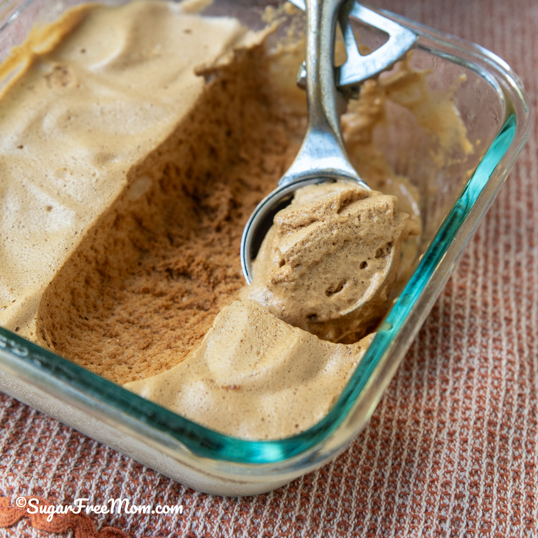 square image of keto frozen whipped Dalgona coffee in a glass dish with an ice cream scoop