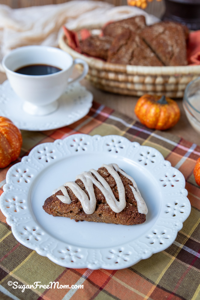 Low Carb Pumpkin Ricotta Scone with Maple Glaze sitting on a white plate over plaid cloth