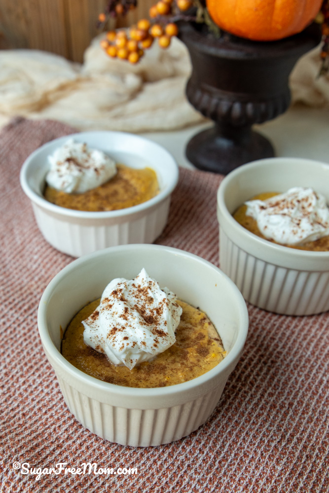 keto Pumpkin Ricotta Custard in 3 small ramekins topped with whipped cream