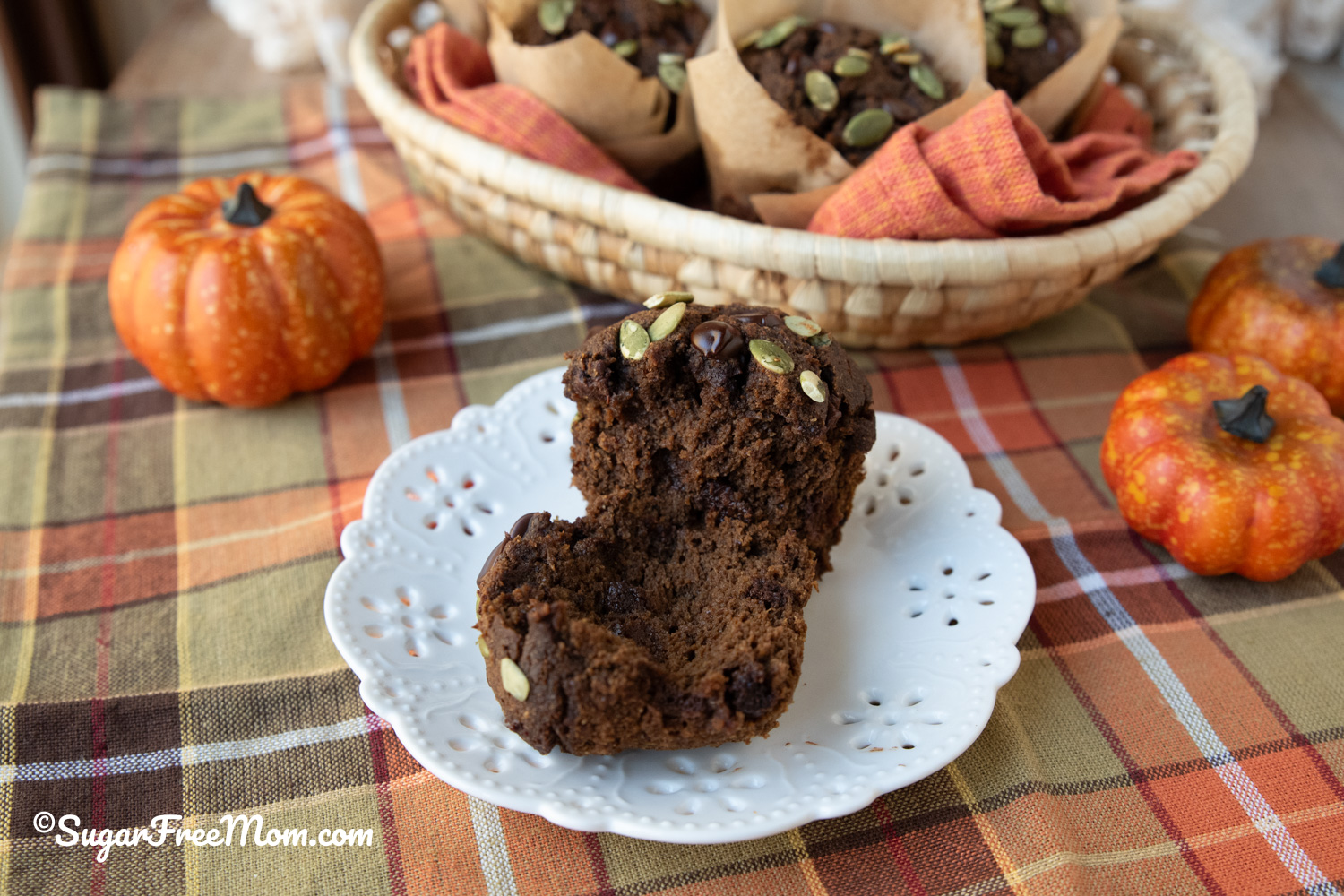 horizontal image of single split in half chocolate pumpkin muffin on a  white plate